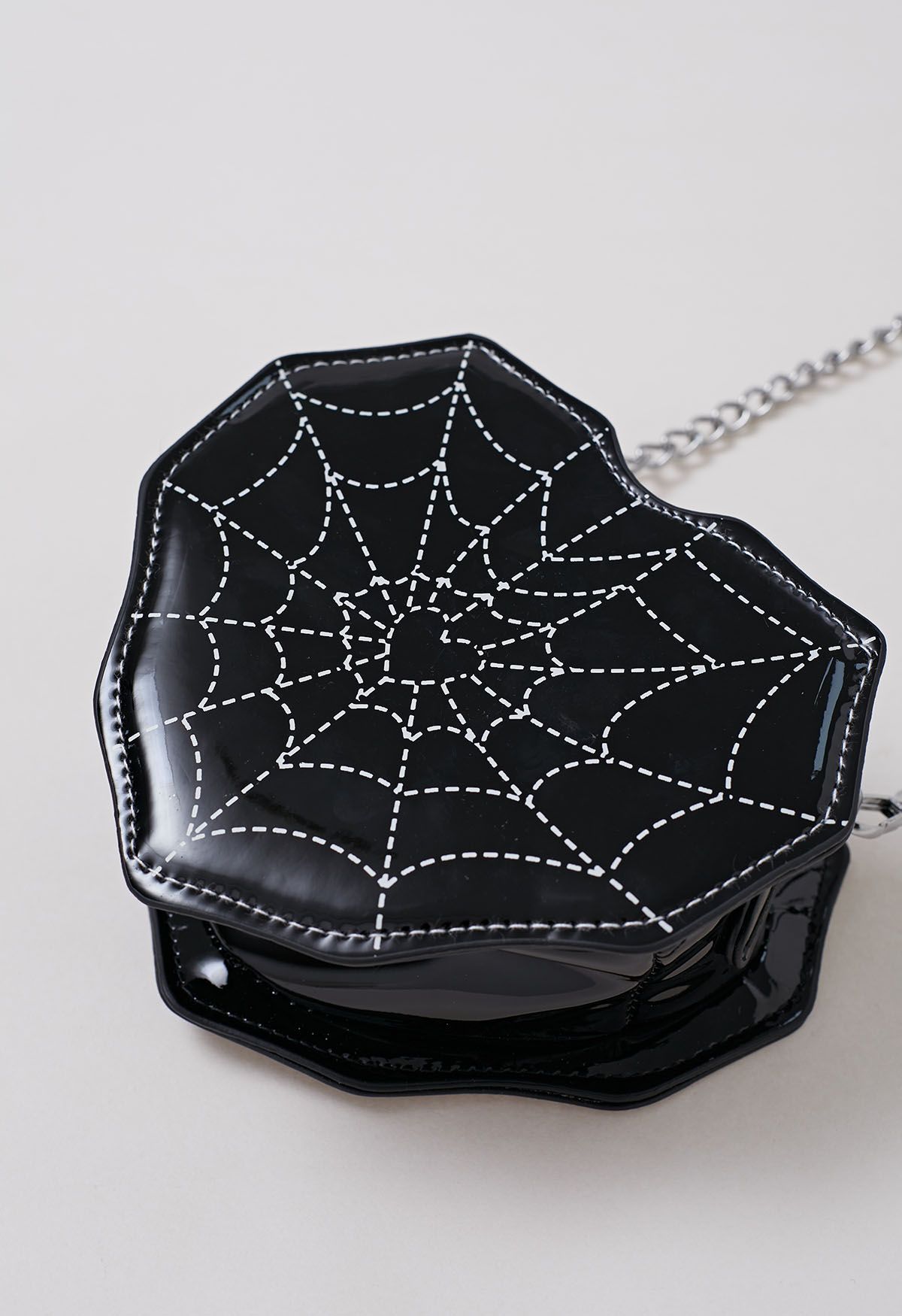 Bolso bandolera con forma de corazón y estampado de telaraña en negro