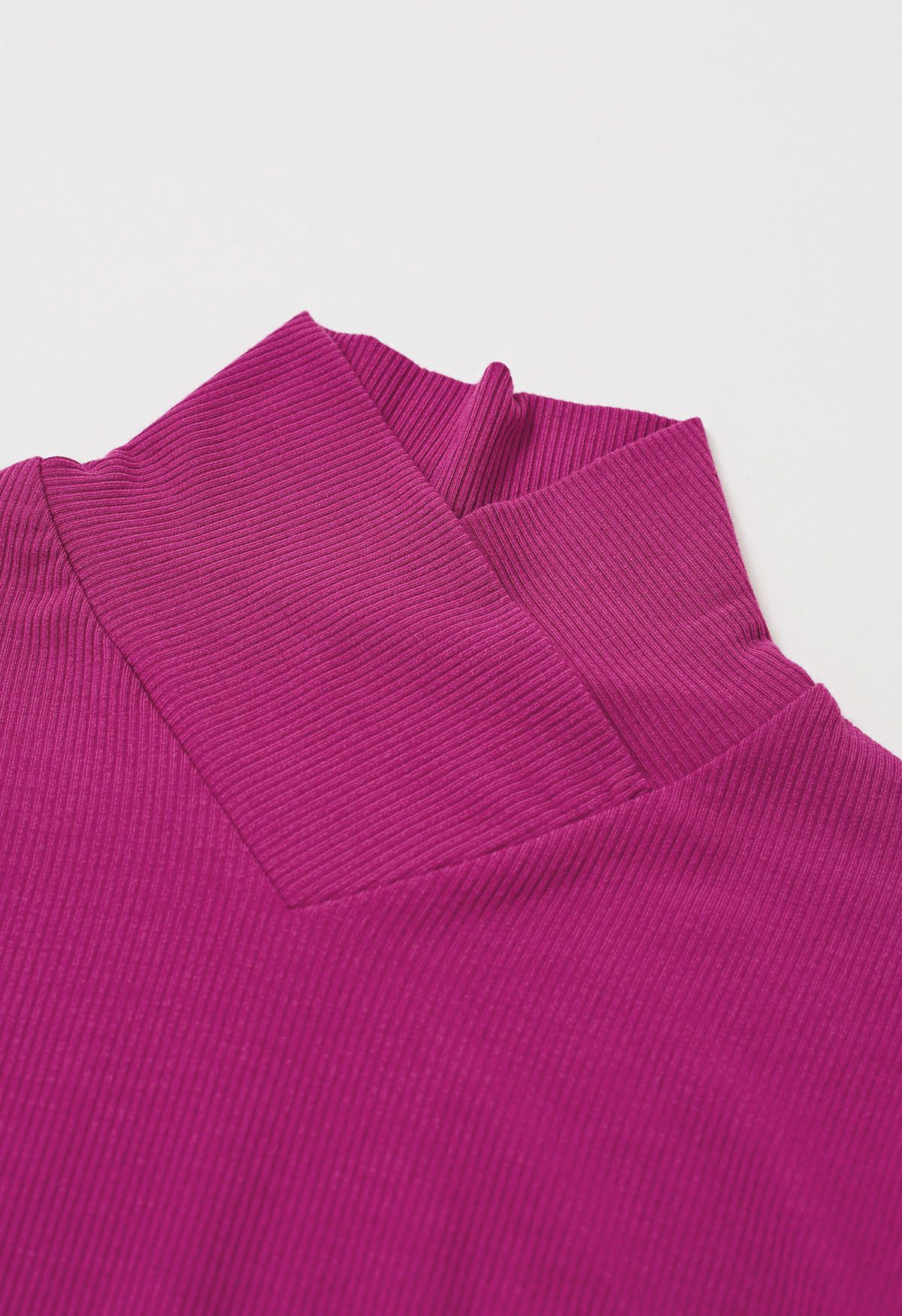 Blusa de manga larga con cuello alto y efecto cruzado en color magenta