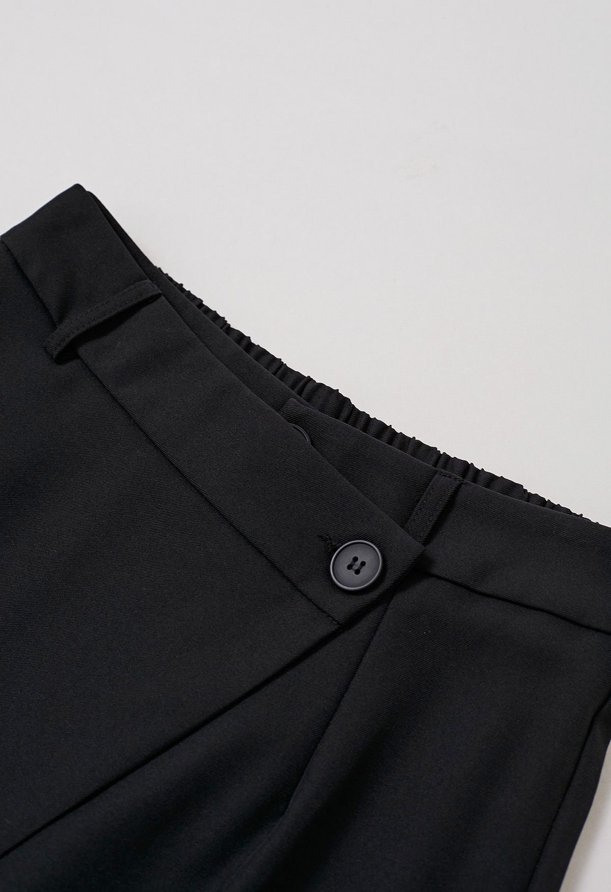 Pantalones rectos con solapa y botones asimétricos en color negro