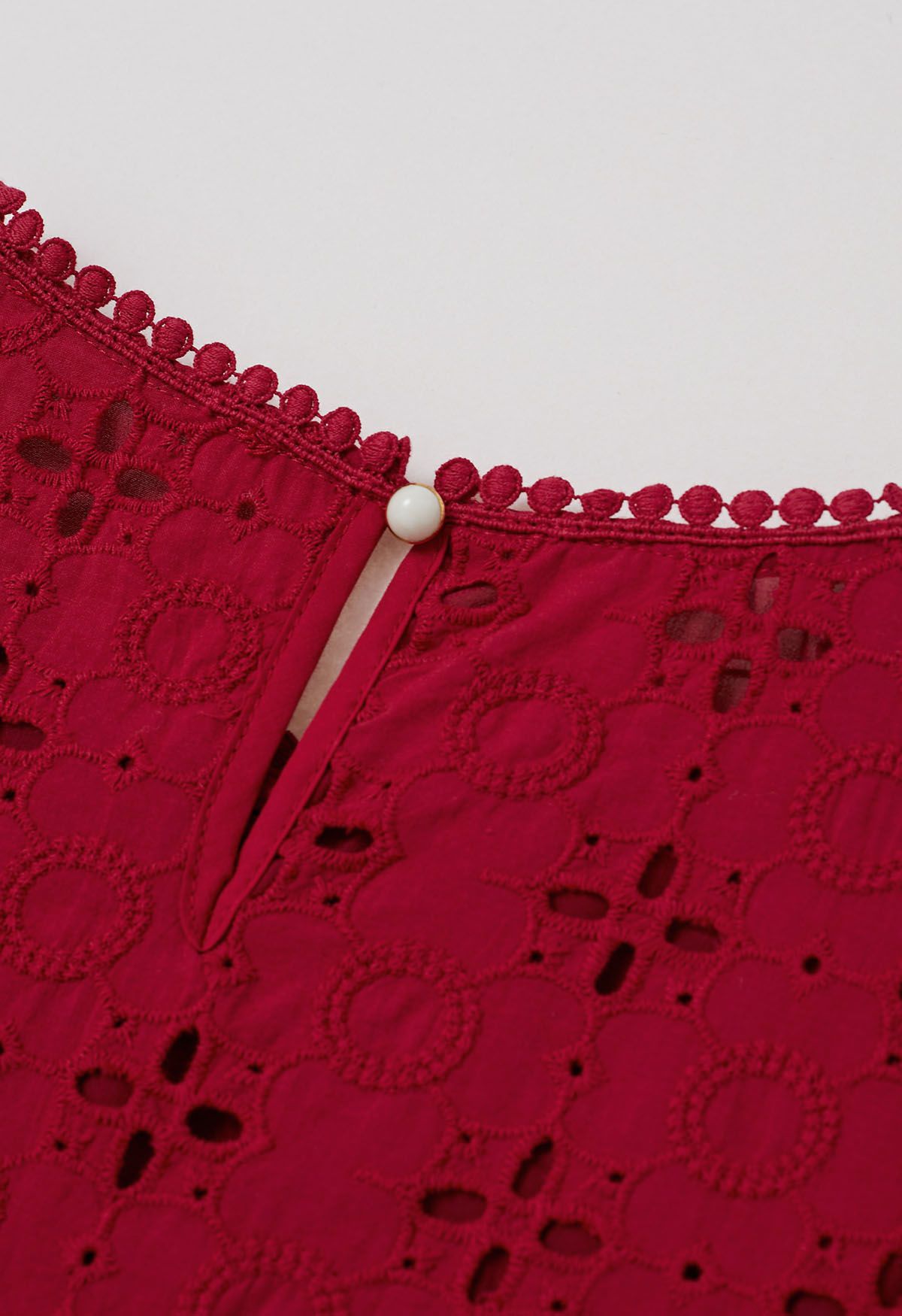 Blusa de algodón con bordado de ojales y pétalos intrincados en rojo