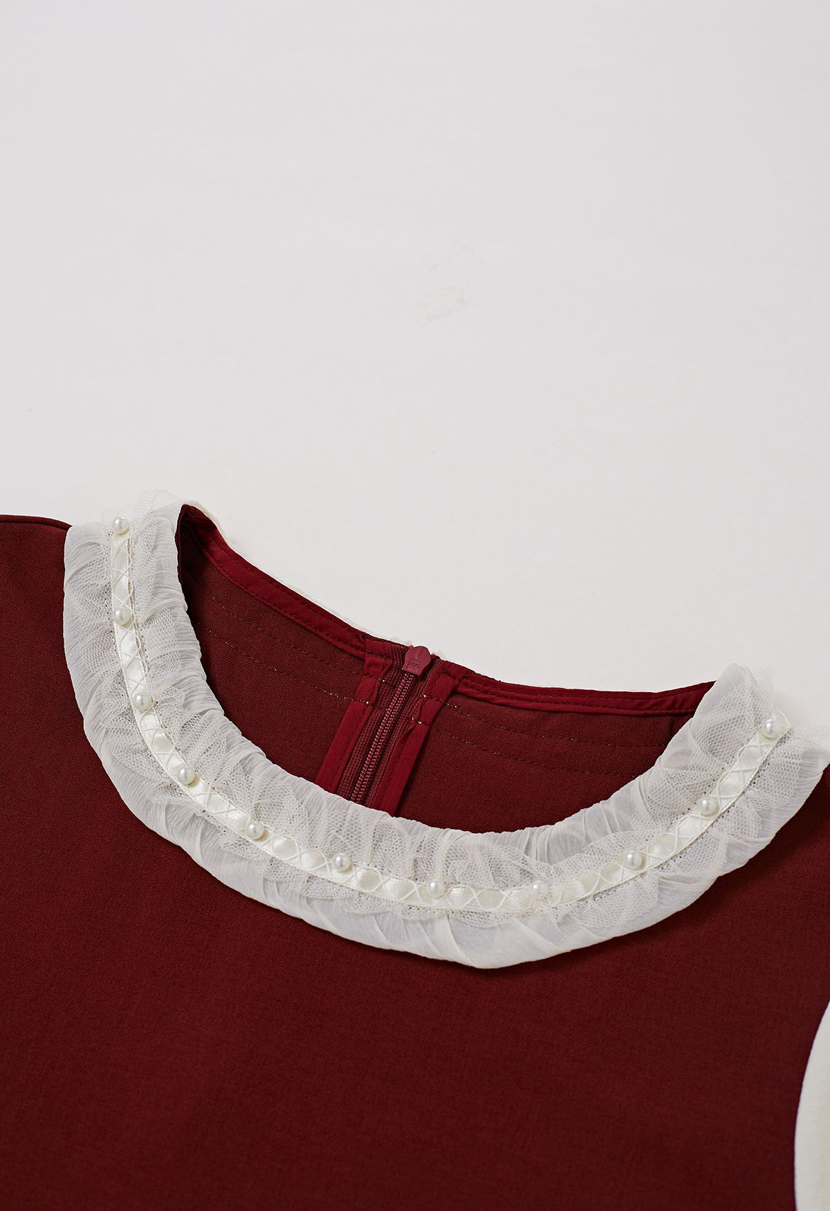 Blusa con cuello con volantes y puños acampanados con ribete de perlas en contraste en rojo