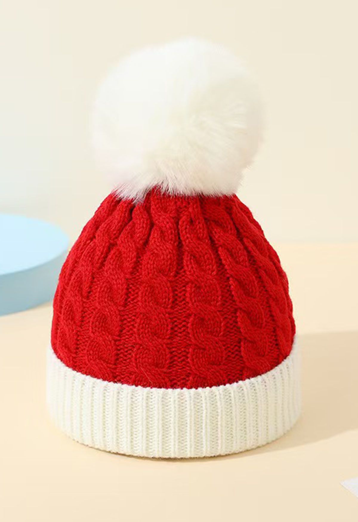 Gorro de punto trenzado con pompones peludos en color rojo