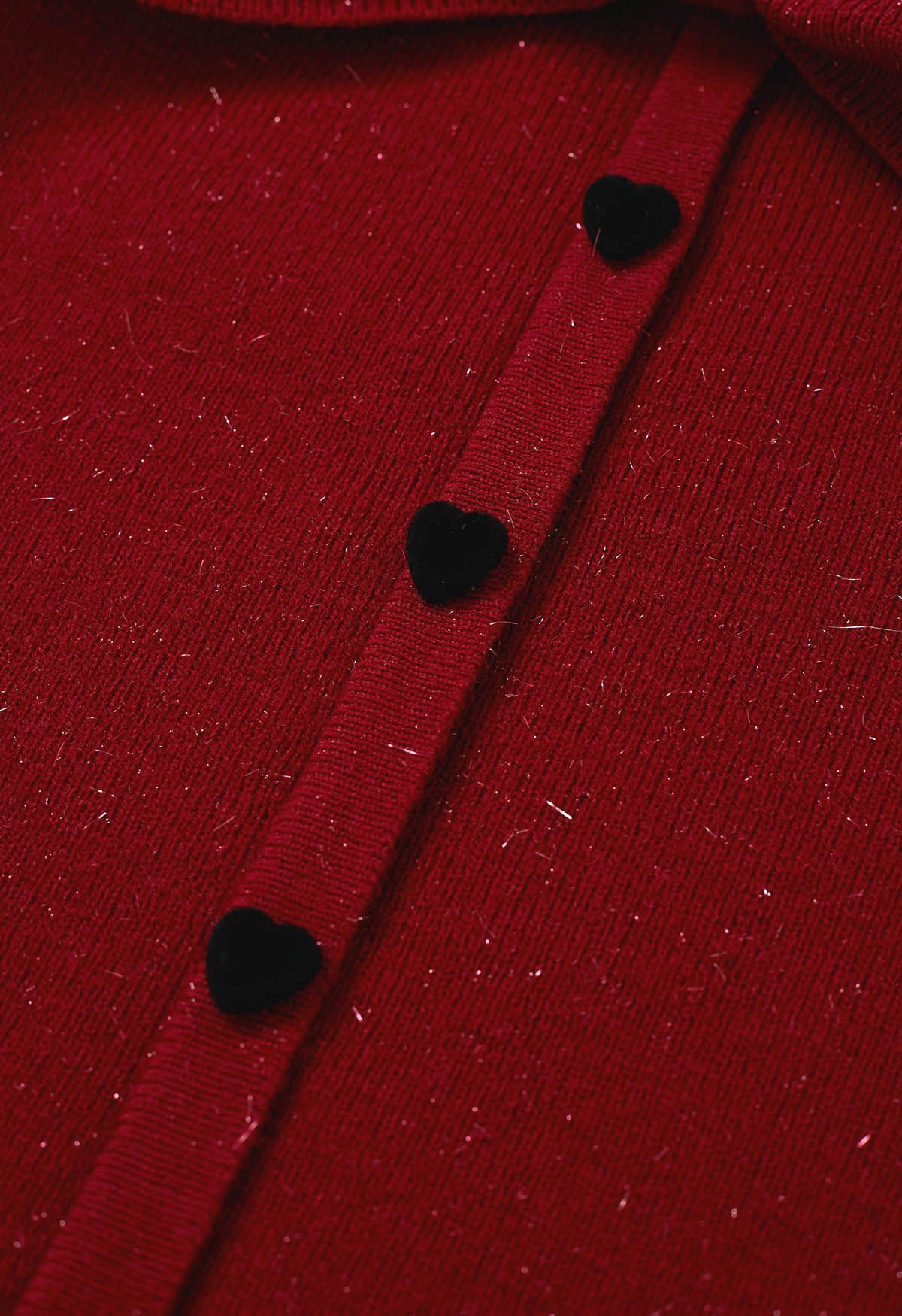 Blusa de punto con botones en forma de corazón, hombros descubiertos y lazo en color rojo