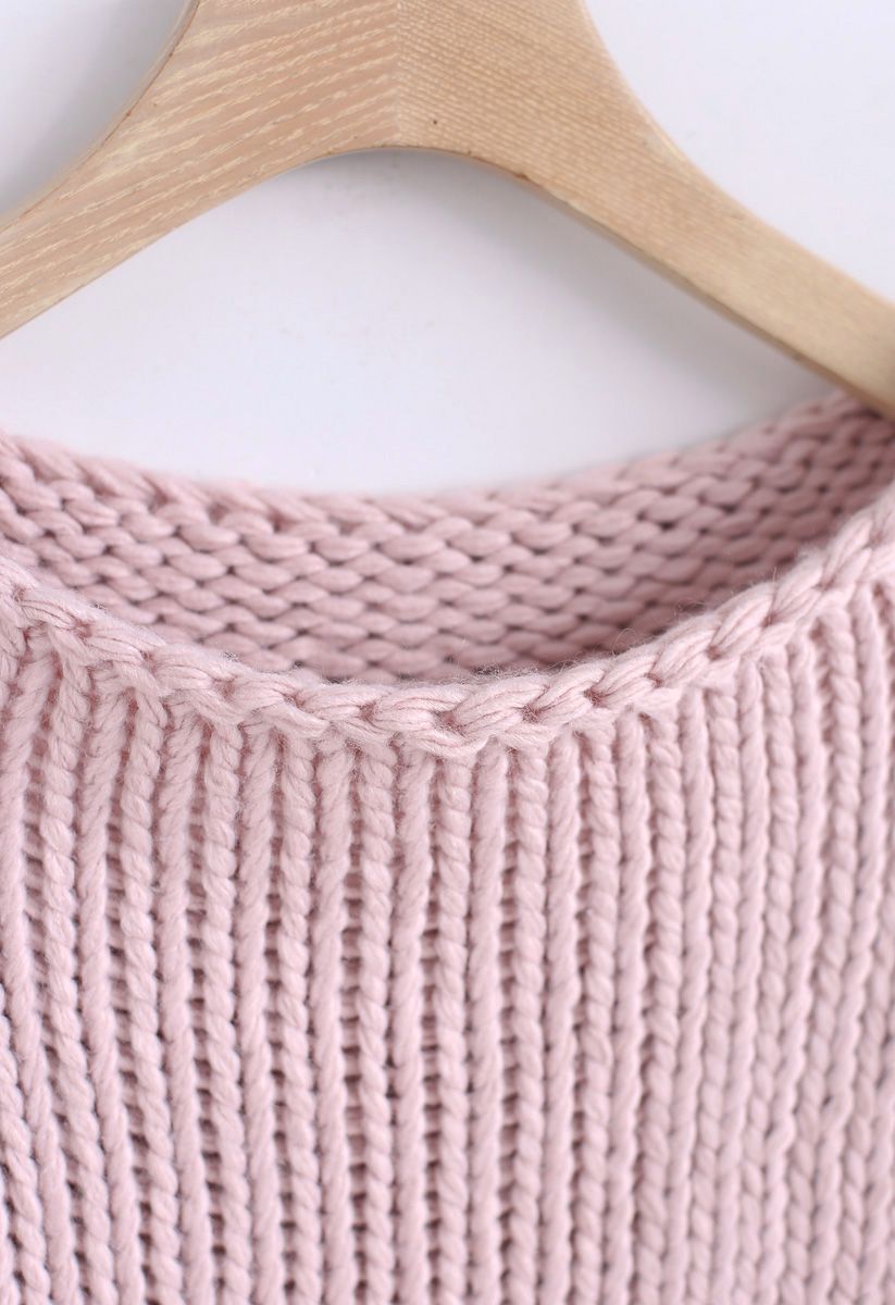 El otro lado del grueso suéter tejido a mano en rosa