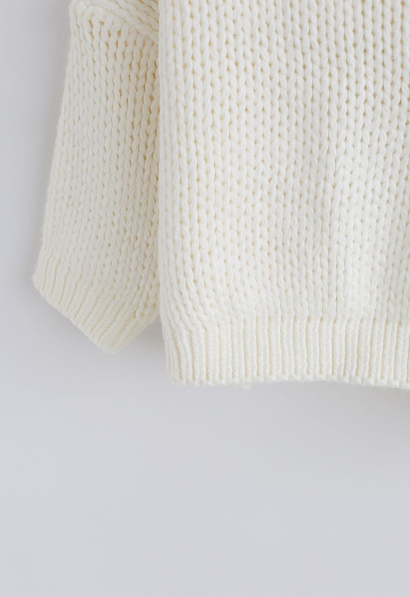 El otro lado del grueso suéter tejido a mano en blanco