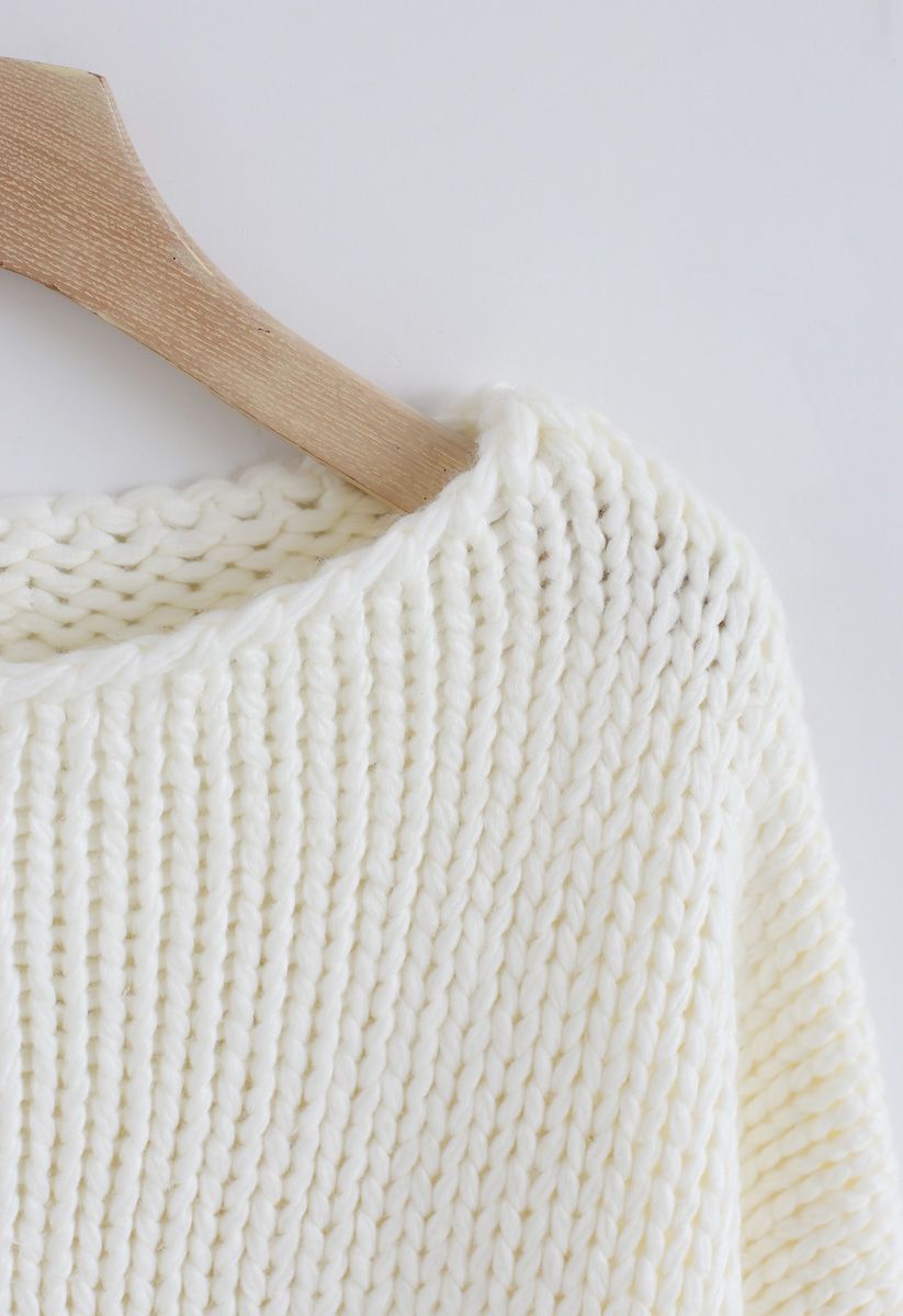 El otro lado del grueso suéter tejido a mano en blanco
