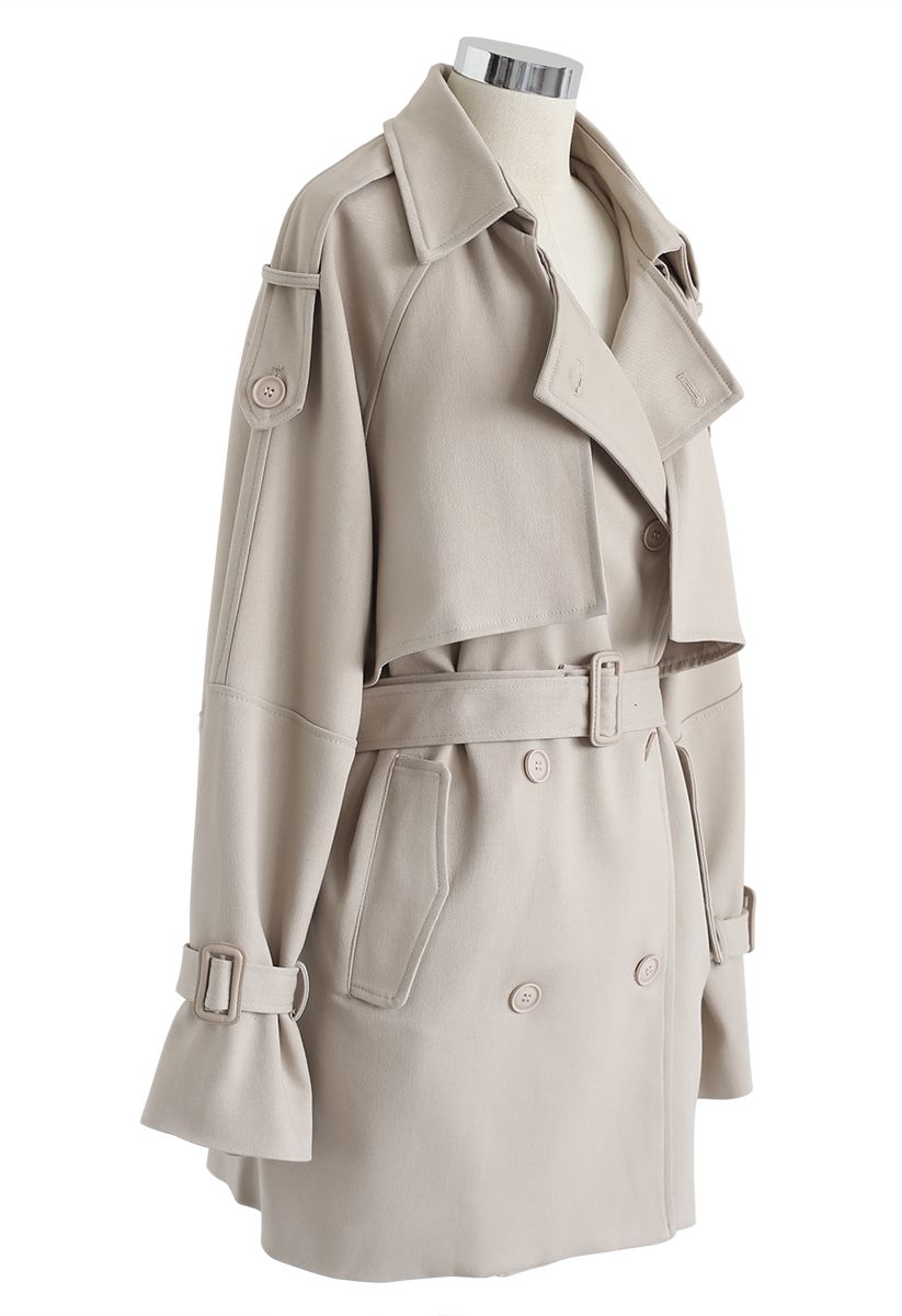 Abrigo con doble botonadura y bolsillos con cinturón en color arena