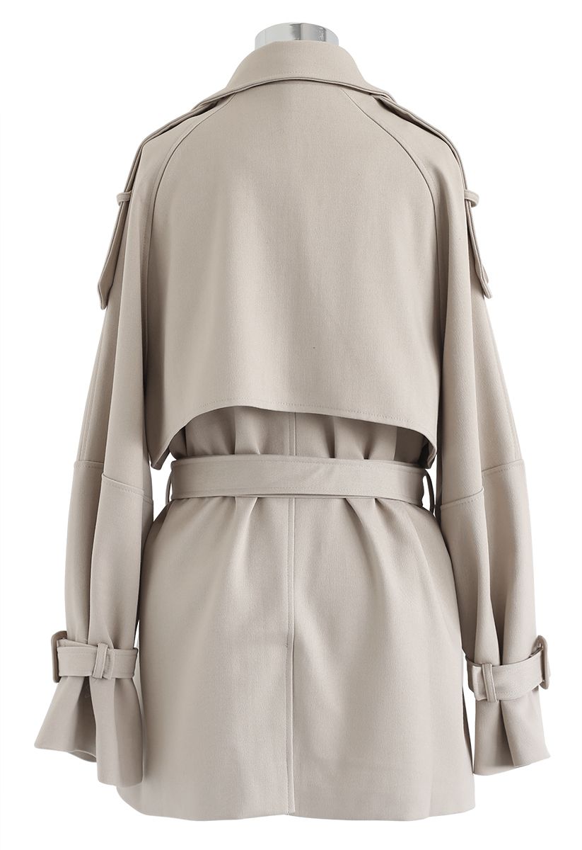 Abrigo con doble botonadura y bolsillos con cinturón en color arena