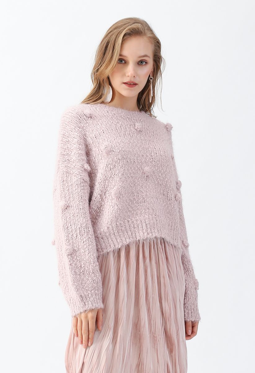 Suéter corto de punto difuso decorado con pompones en rosa