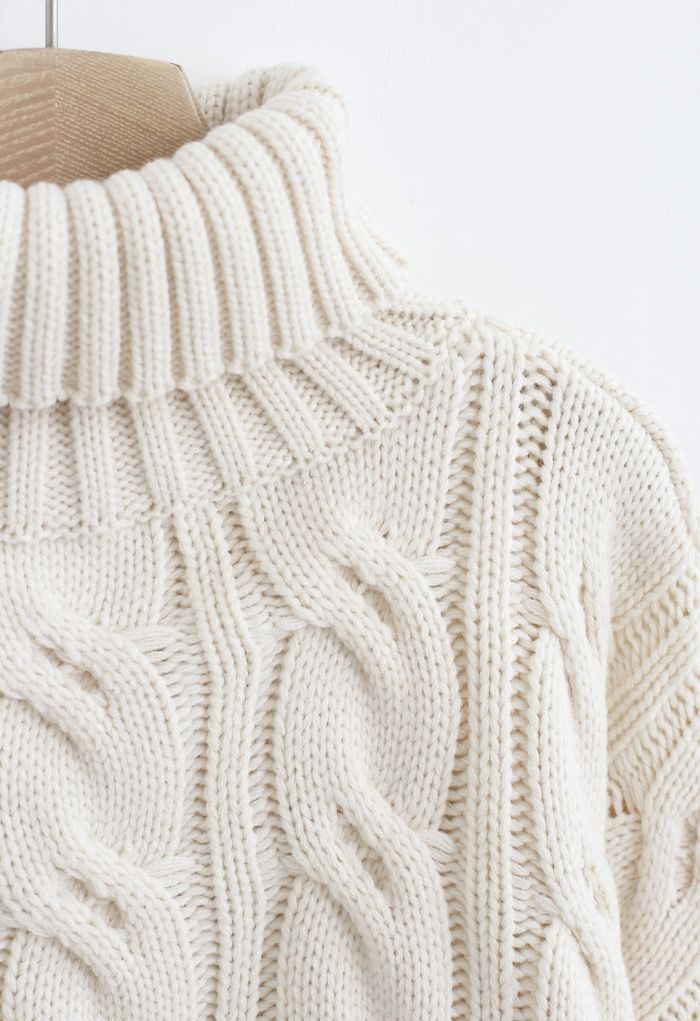Suéter corto de punto trenzado con cuello alto en color arena