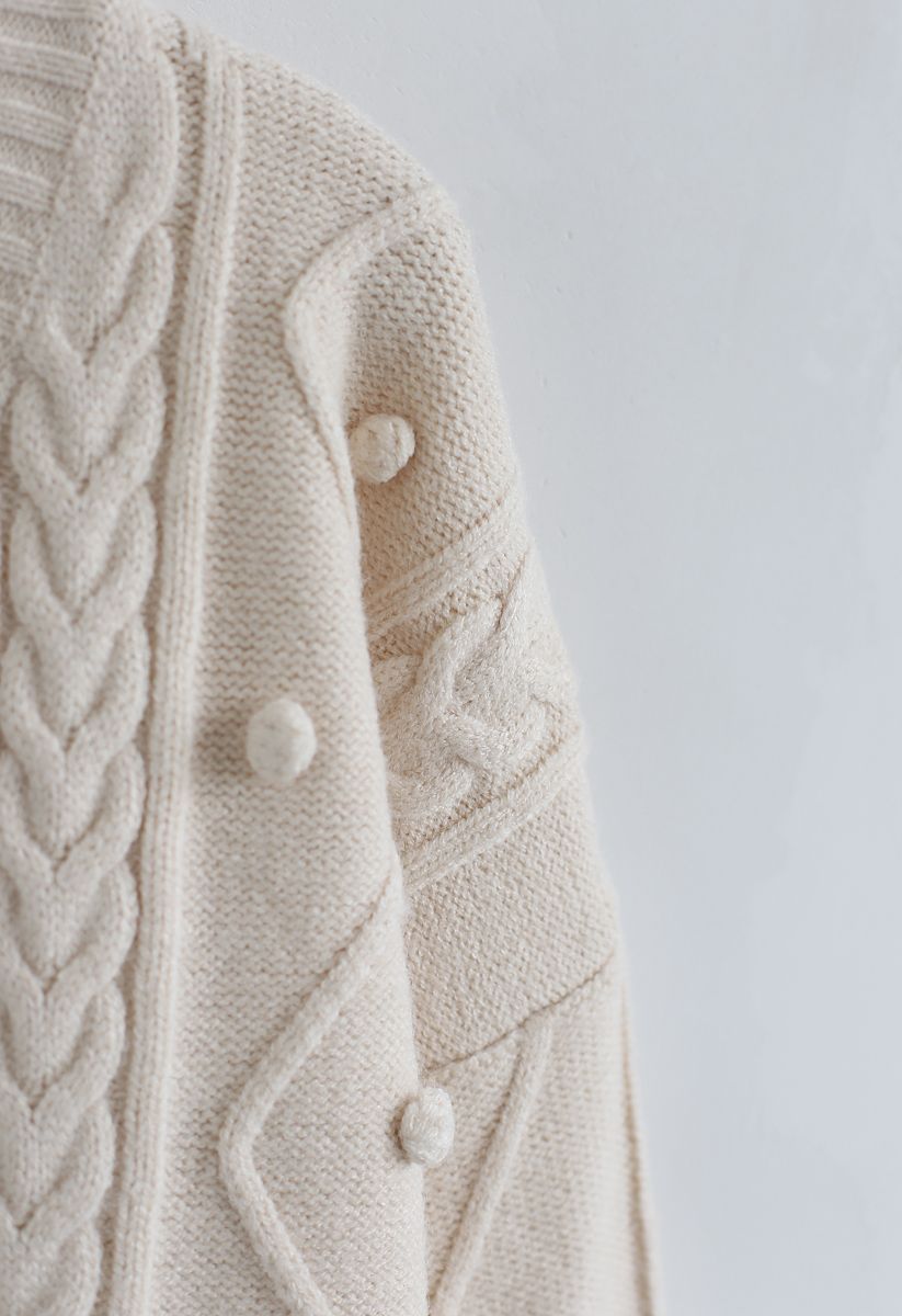 Suéter de punto con cuello en V y trenza con pompones en color crema
