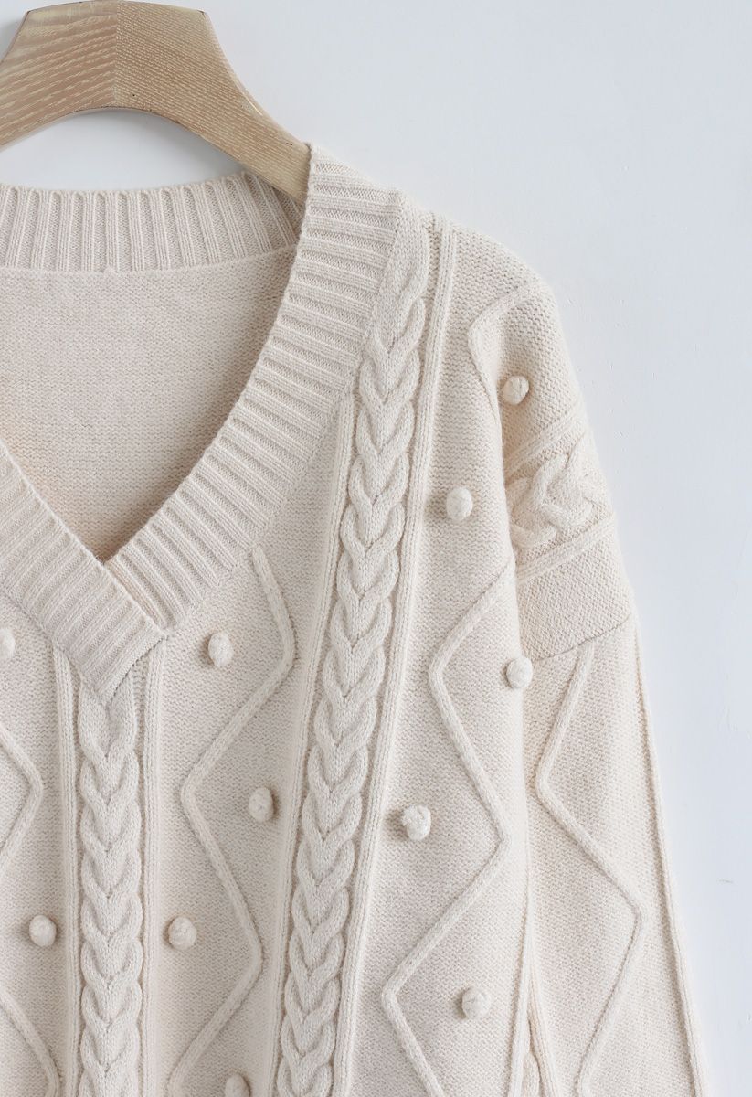 Suéter de punto con cuello en V y trenza con pompones en color crema