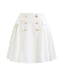 Minifalda plisada con sutiles botones dorados en blanco
