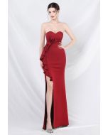 Vestido sin tirantes con abertura y volantes en la cintura con lazo en rojo